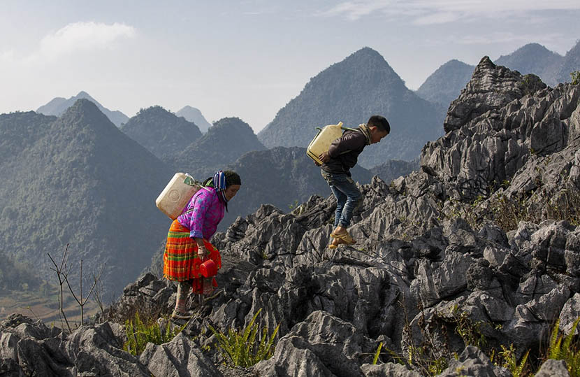 colorful-life-in-the-mountain-of-vietnam-8 old womand and child taking water in dong van